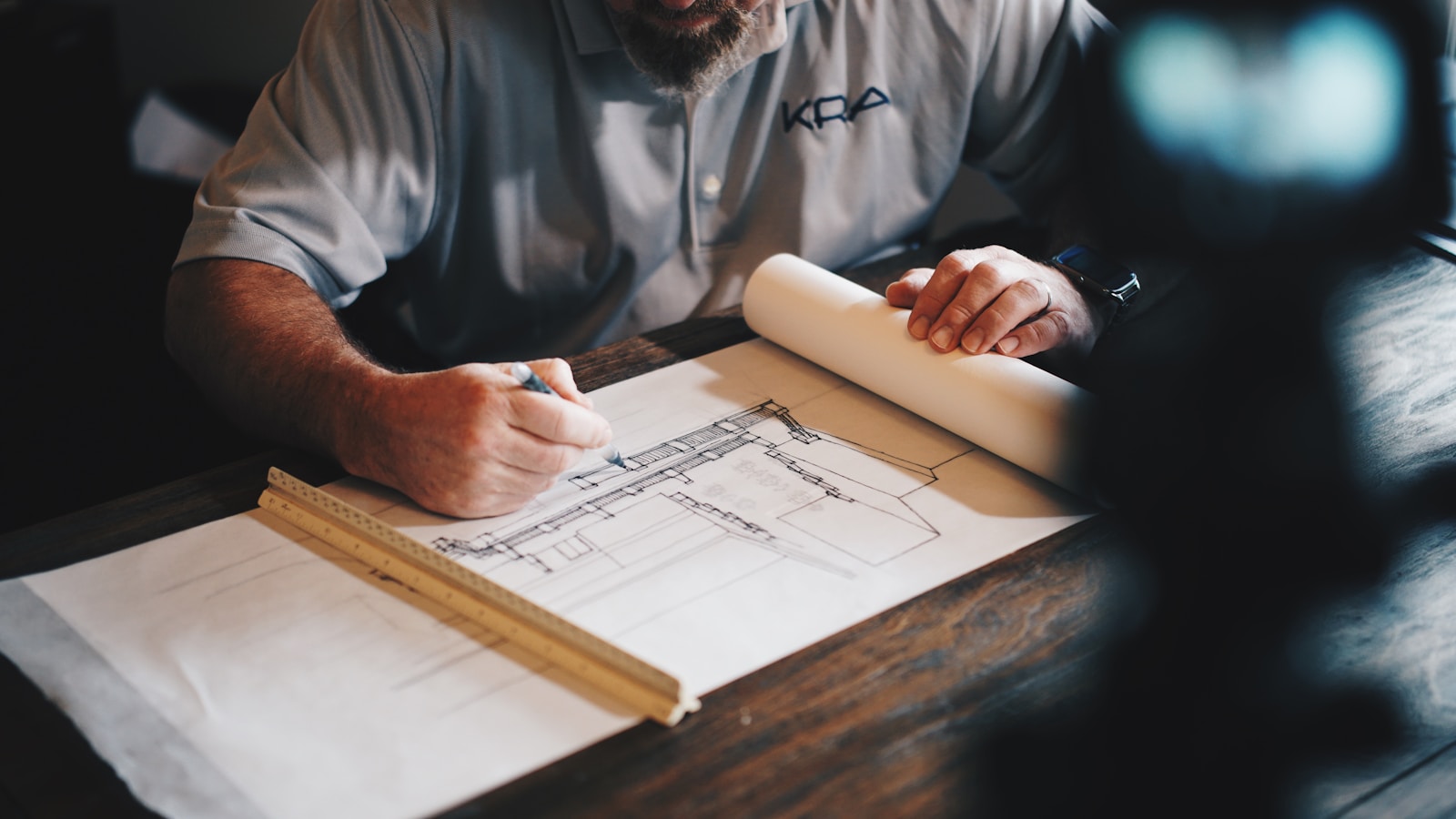 Engineer reviewing floorplans alongside workflow documentation and portfolio control matrices